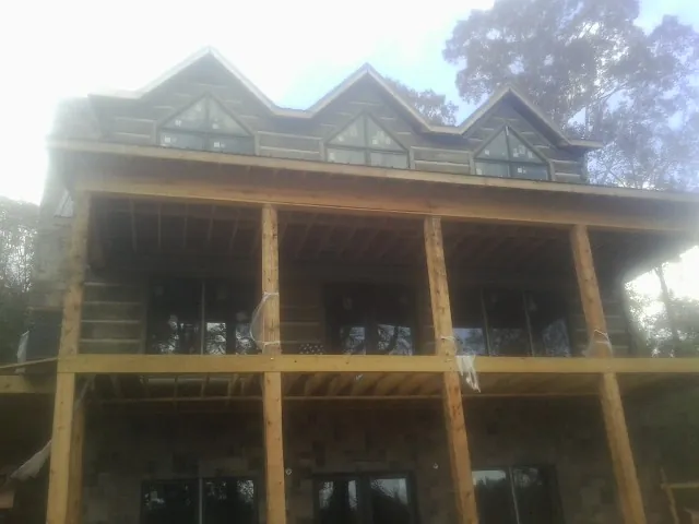 Dormers and porch framing on a large log home under construction — Roof Coating work by our crew in Shamokin