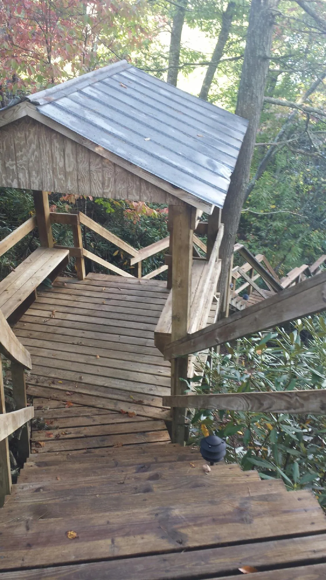 Metal roofed shelter over wooden steps on a wooded walkway — Skylight Repair & Installation work by our crew in Shamokin